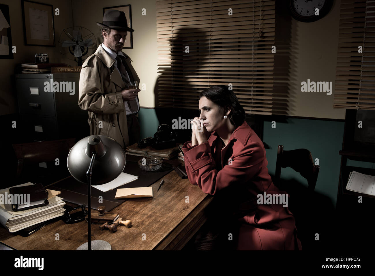 Entrevue avec un détective jeune femme triste dans son bureau, scène du film noir. Banque D'Images