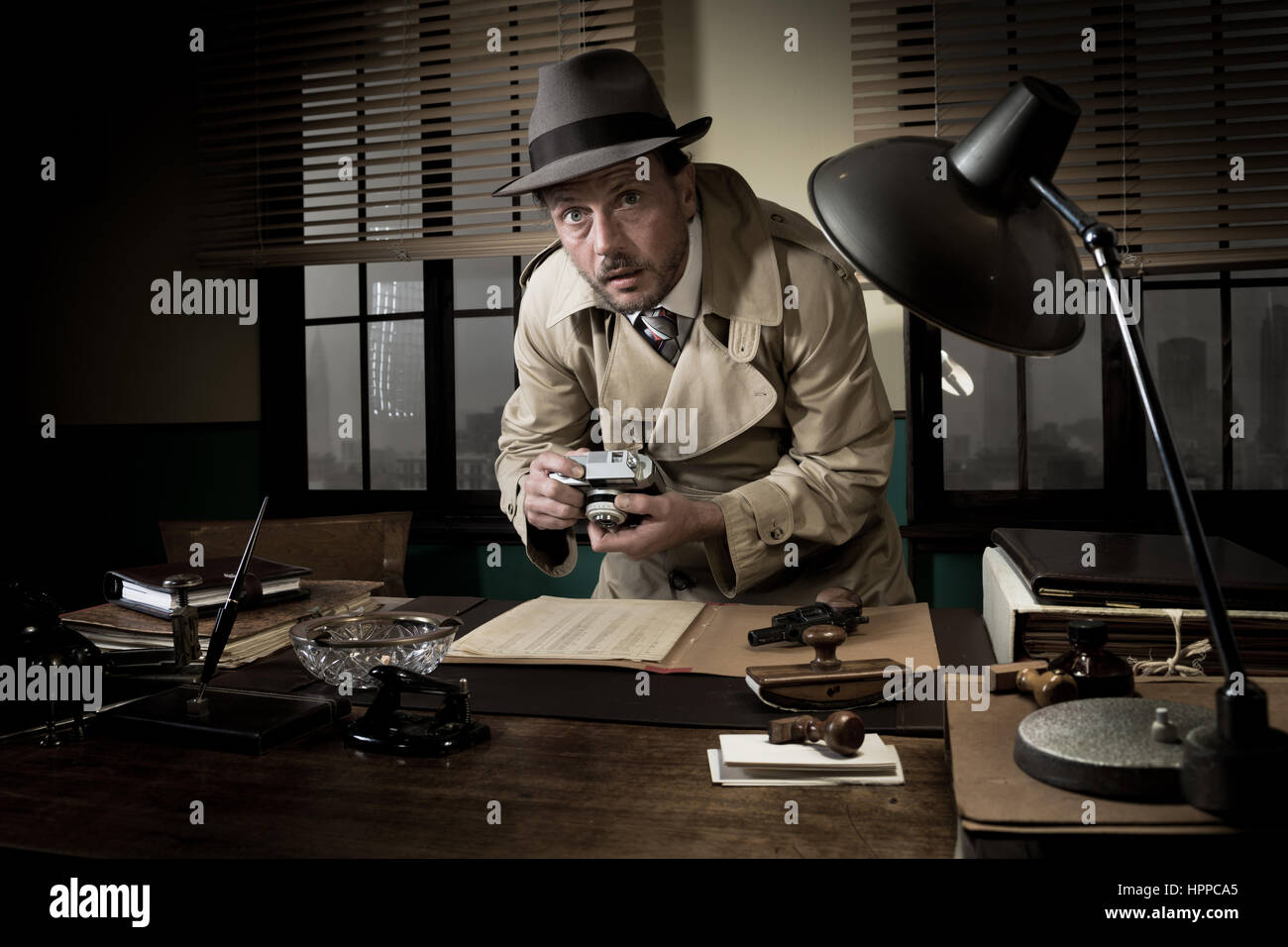 Incarnez un agent rétro pris la photographie d'importants documents sur Office 24, style années 50. Banque D'Images
