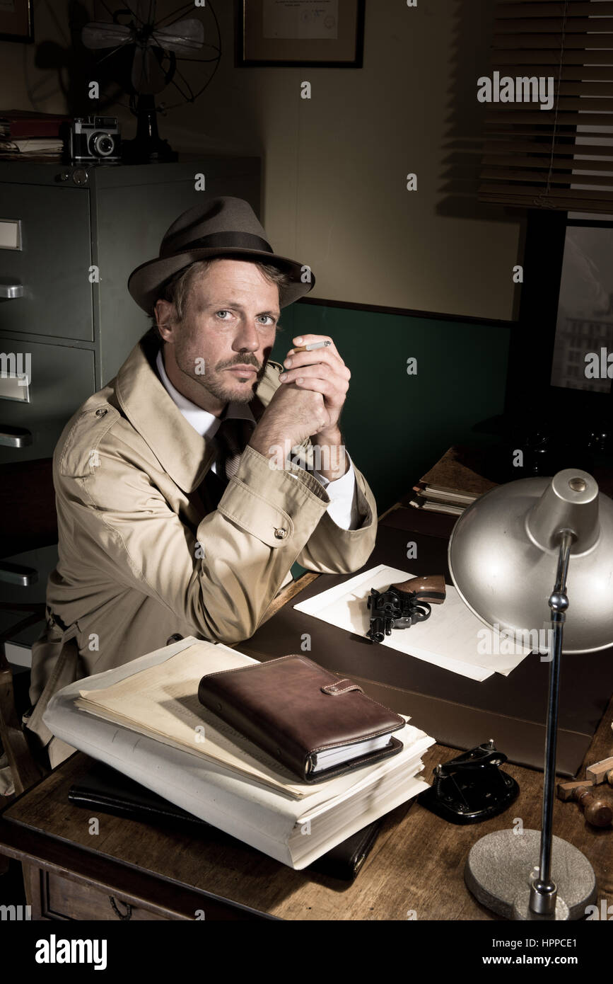 Certains fumeurs détective à 24 en trench coat, 1950 film noir style. Banque D'Images