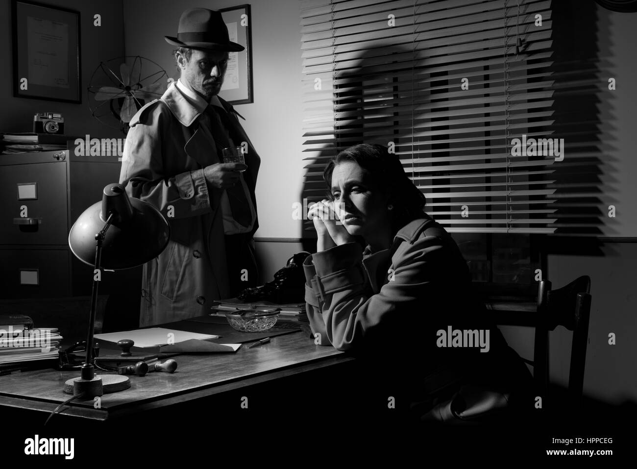 Entrevue avec un détective jeune femme triste dans son bureau, scène du film noir. Banque D'Images