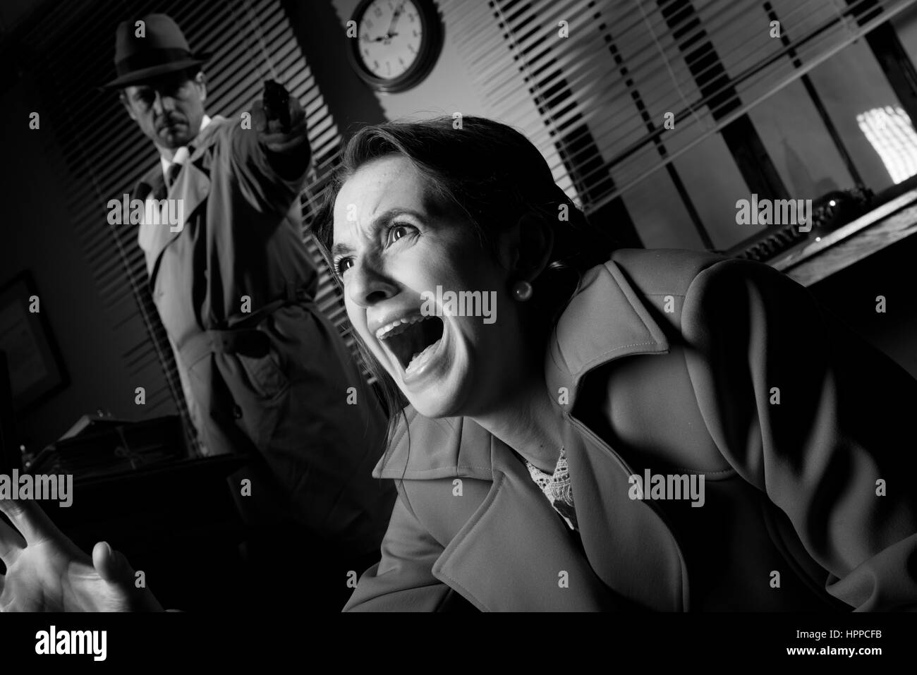 Article détective dans l'obscurité et de braquer une arme à une femme crier. Banque D'Images