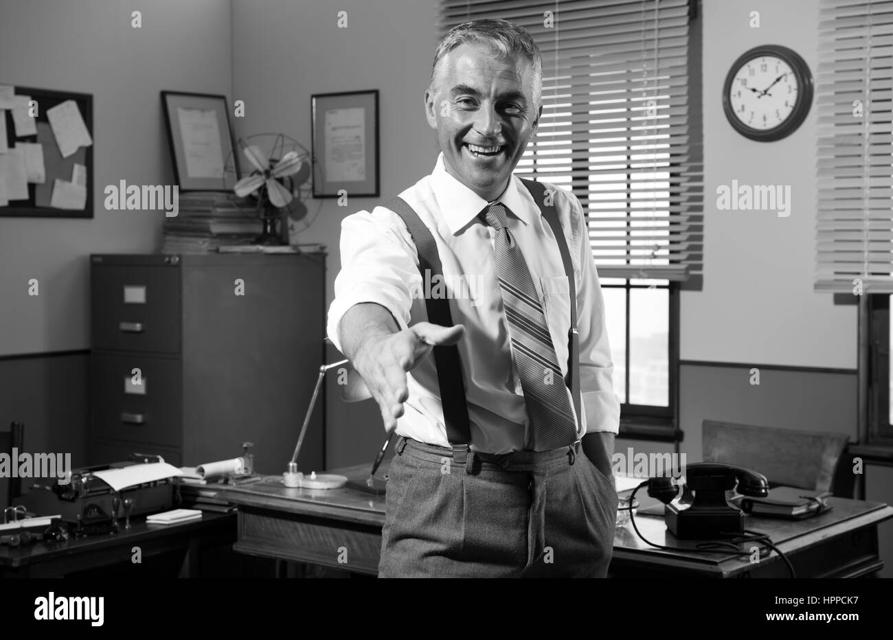 Vintage smiling businessman donnant prise dans son bureau. Banque D'Images