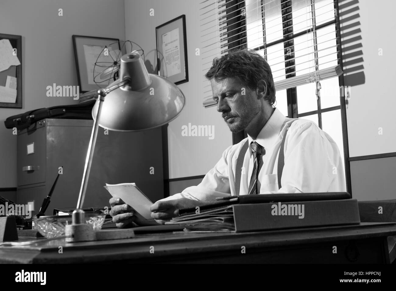 Directeur bureau Vintage travaillant au bureau à lire des documents. Banque D'Images