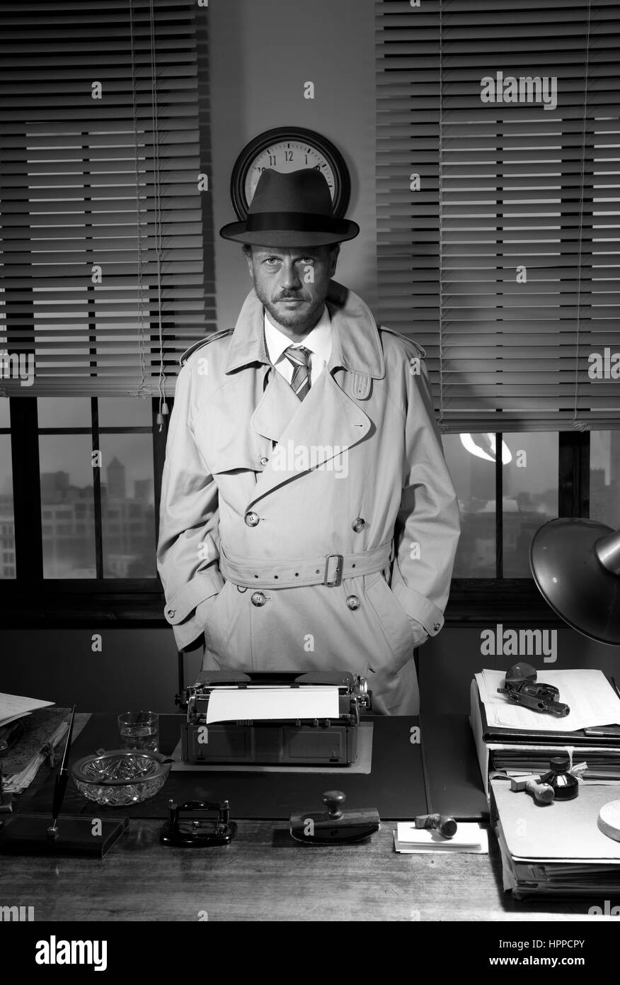 Détective attrayant debout à côté de son bureau, 1950 Bureau de style. Banque D'Images