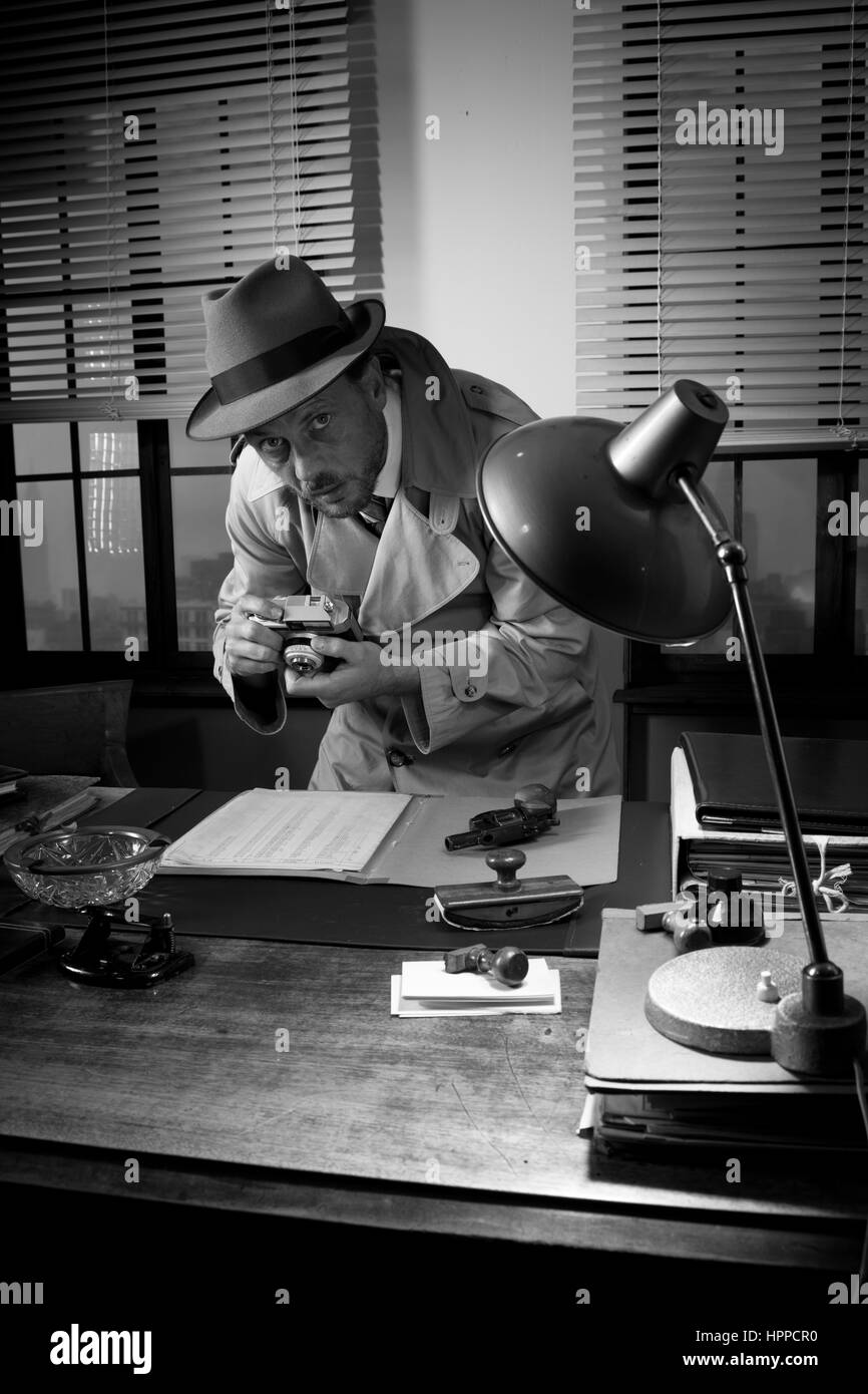 Incarnez un agent rétro pris la photographie d'importants documents sur Office 24, style années 50. Banque D'Images