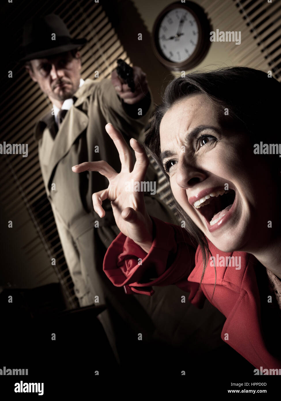 Article détective dans l'obscurité et de braquer une arme à une femme crier. Banque D'Images