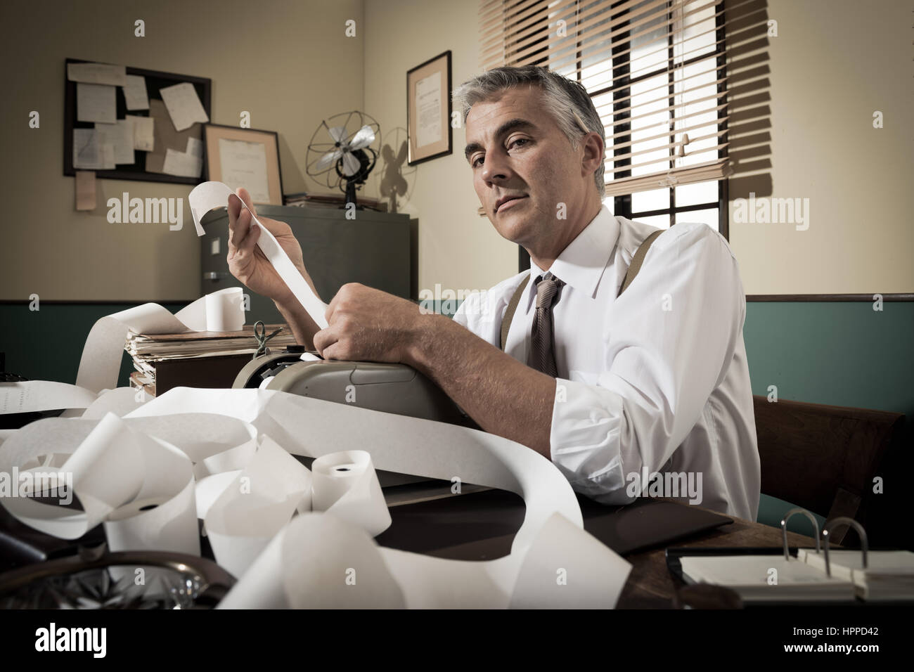 Comptable professionnel travaillant avec l'ajout de bande dans la machine de bureau vintage. Banque D'Images