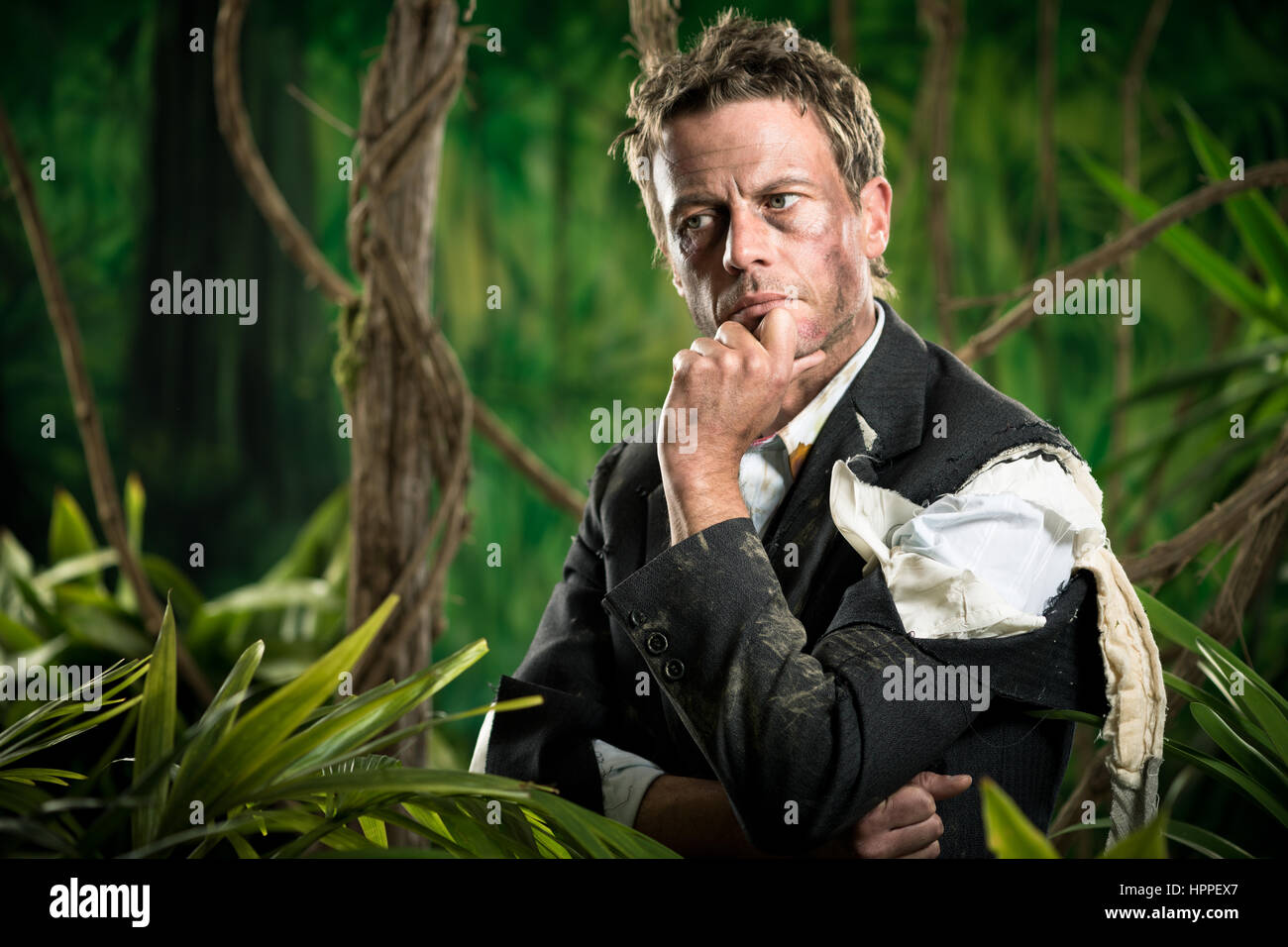 Businessman perdu dans la pensée de la jungle en toute confiance avec la main sur le menton. Banque D'Images Businessman perdu dans la pensée de la jungle en toute confiance avec la main sur le menton. Banque D'Images