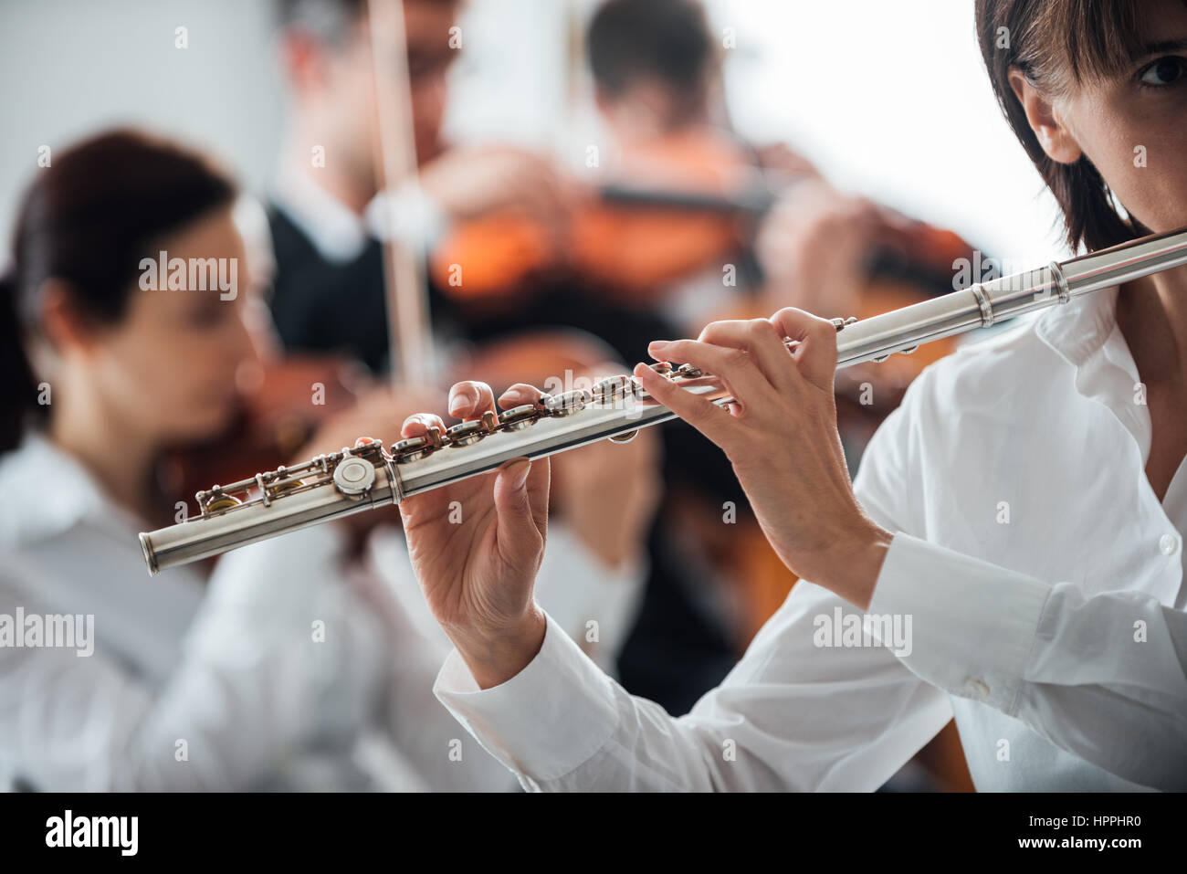 Les femmes professionnelles flute player jouer avec l'orchestre symphonique  de la musique classique, personne méconnaissable Photo Stock - Alamy