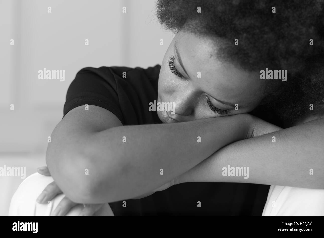 Young african american woman relaxing et appuyée sur son bras avec les yeux fermés Banque D'Images