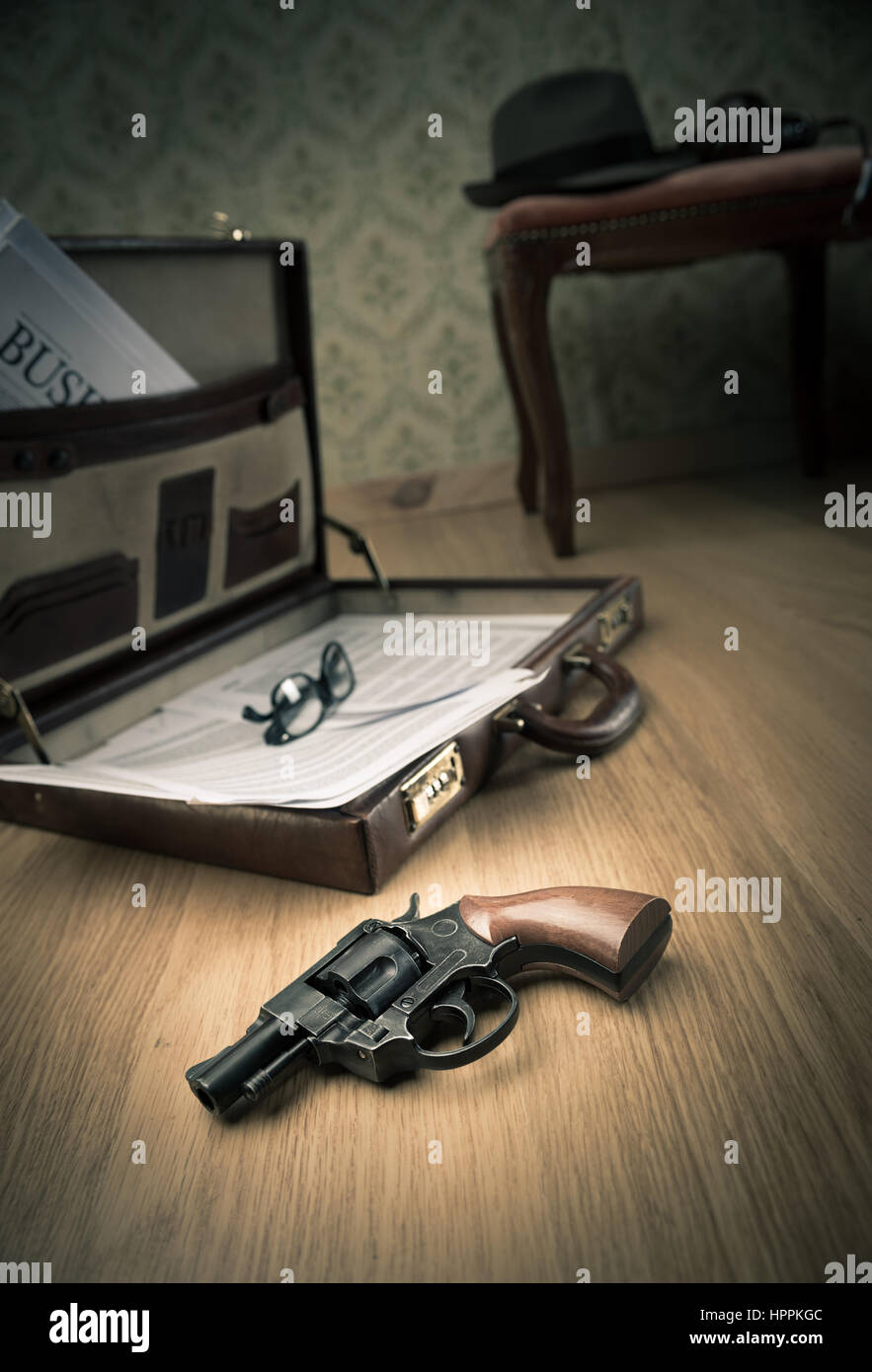 Detective Ouvrez porte-documents avec vintage gun sur le plancher et borsalino chapeau sur arrière-plan. Banque D'Images