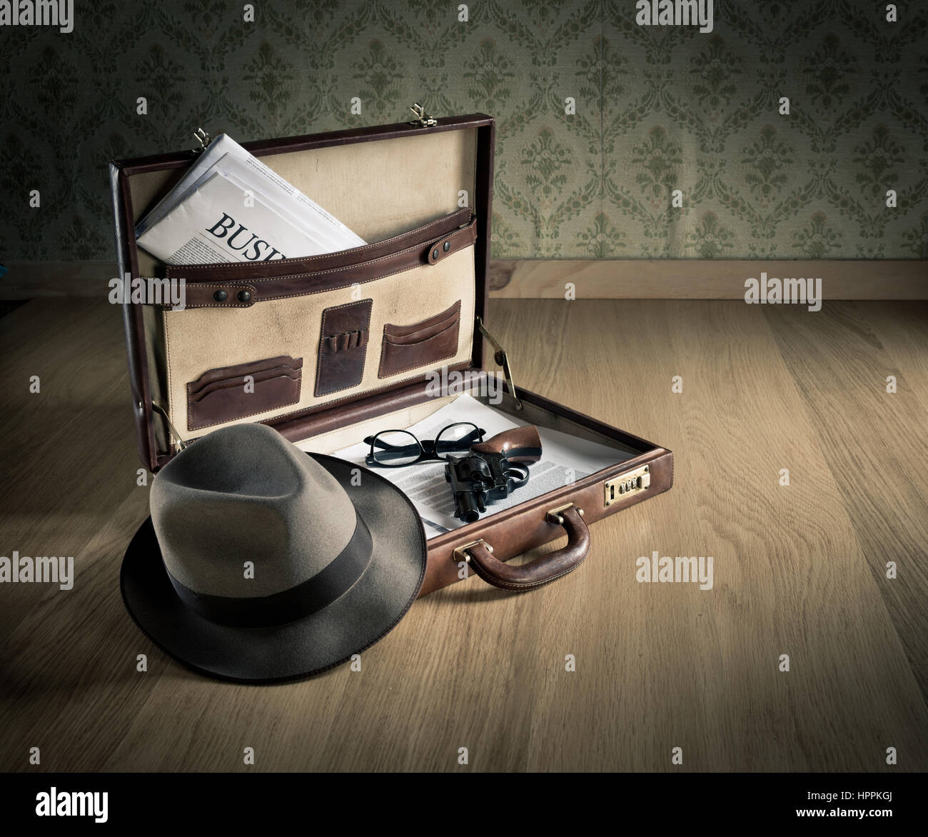 Porte-documents en cuir vintage ouvert avec chapeau de détective, revolver fusil et journal. Banque D'Images