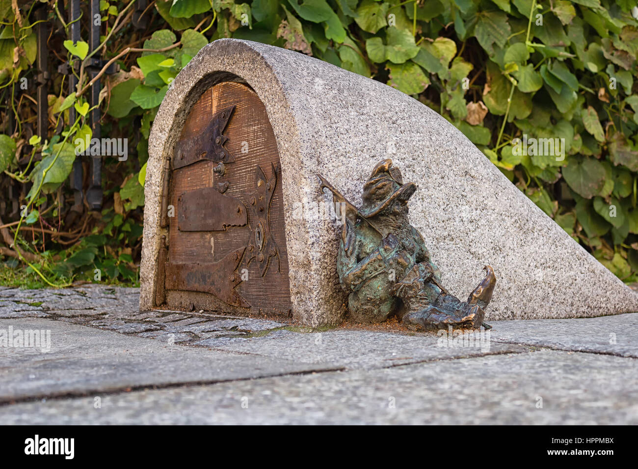 Un nain, symbole de Wroclaw en Pologne garde l'entrée d'un petit immeuble, dormir à côté de la porte Banque D'Images