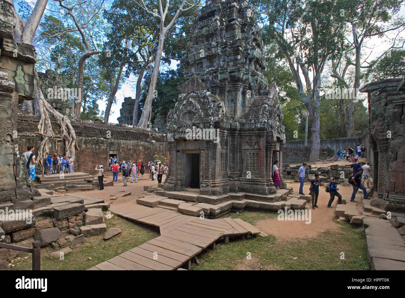 Une vue grand angle de touristes passant dans le complexe du temple Ta Prohm, Angkor. Banque D'Images