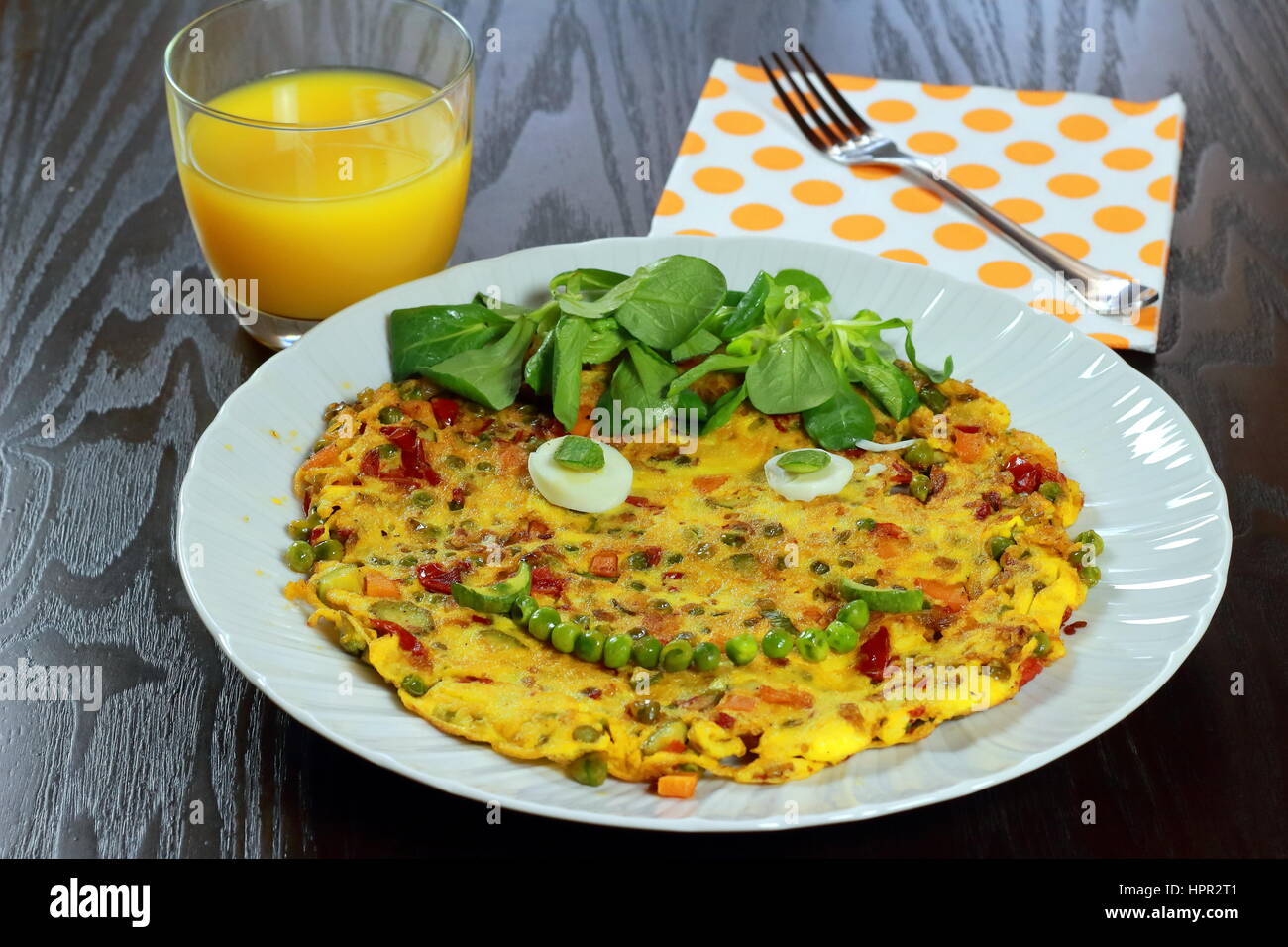 Omelette végétarienne smiling for kids fiche prêt à être servi dans l'alimentation des enfants - plat blanc sur table en bois foncé avec du jus d'orange, doublures et fourchette Banque D'Images