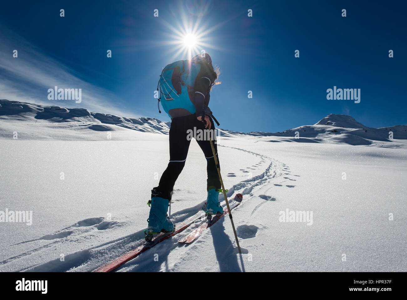 Ascension avec ski alpinisme et escalade skins pour une femme seule dans un paysage de neige Banque D'Images