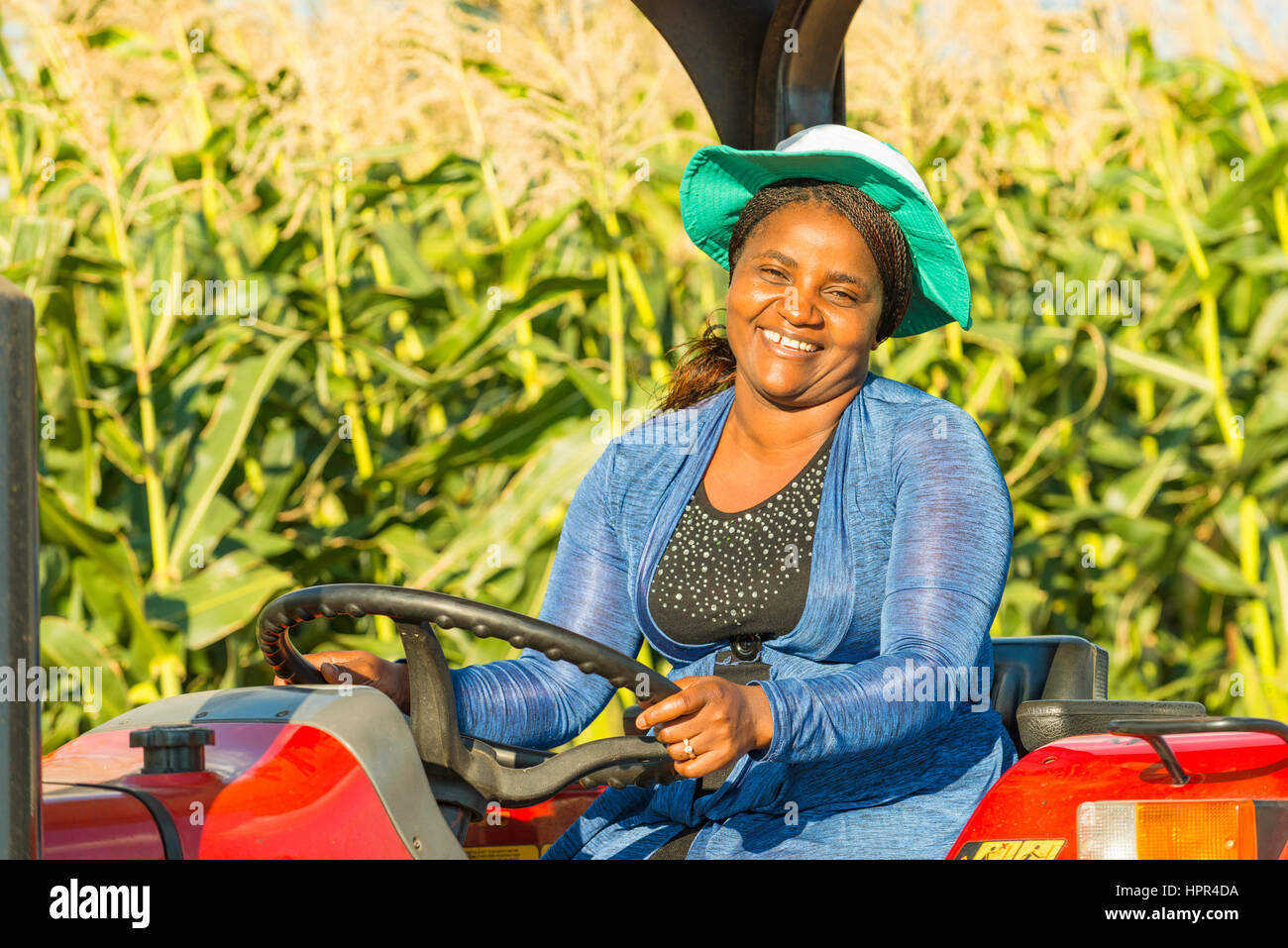 Une femme assise sur un tracteur au Zimbabwe. Banque D'Images