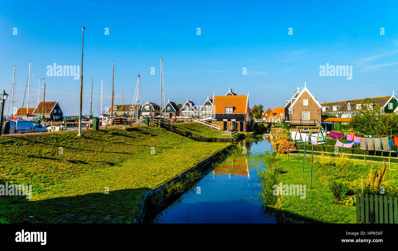 Maisons traditionnelles typiques avec mur vert et toit en tuiles rouges dans le village de pêcheurs historique de Marken aux Pays-Bas Banque D'Images
