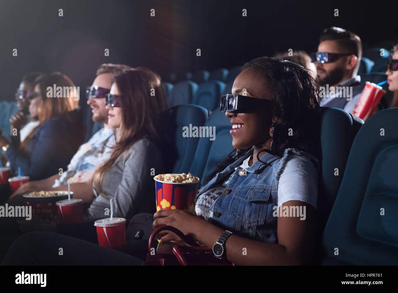 Heureux de voir ce film. Tourné d'une femme africaine portant des lunettes 3D tout en regardant un film au cinéma Banque D'Images
