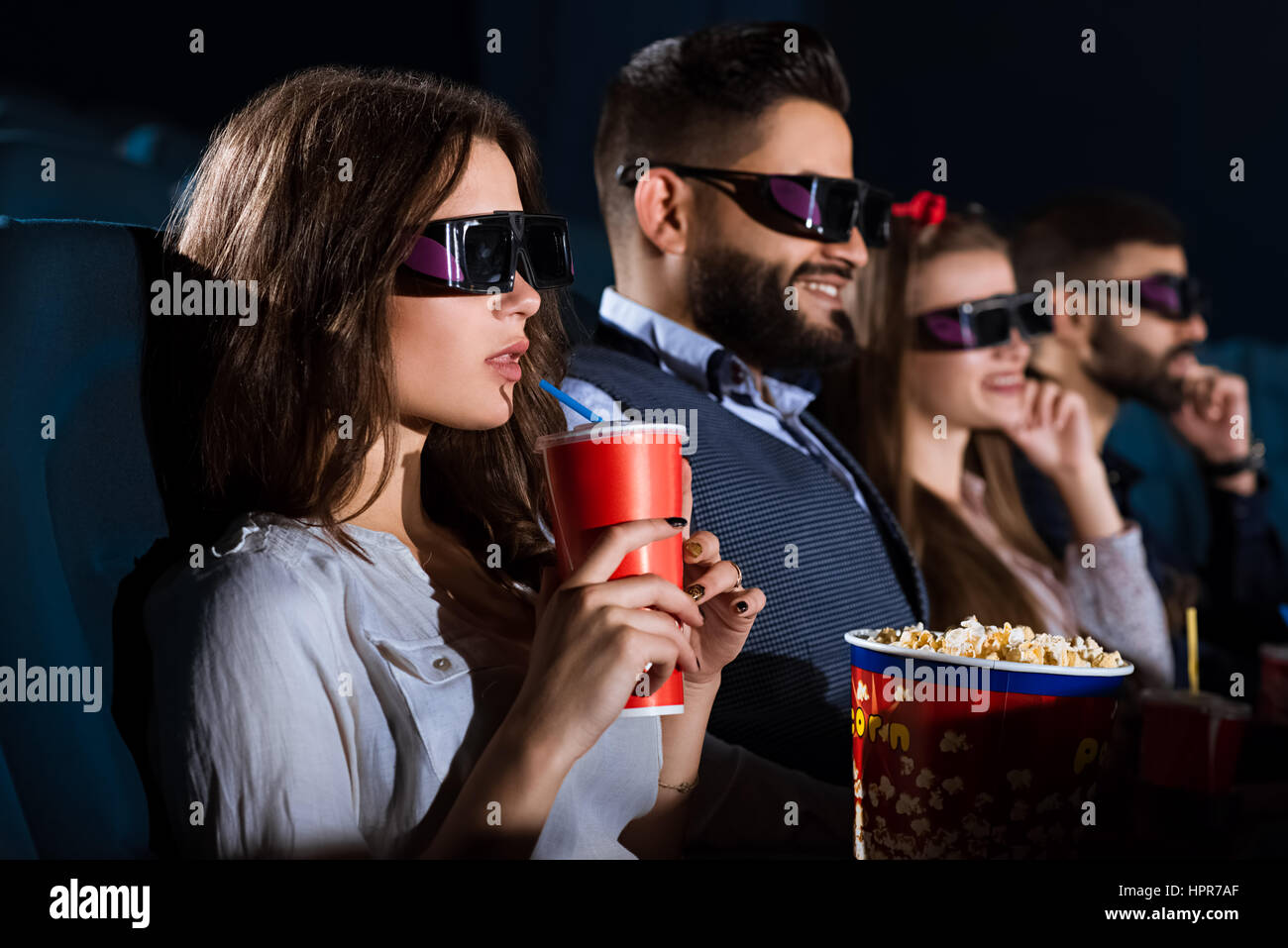 Date double. Libre tourné de deux jeunes couples de regarder un film sur une date double au cinéma Banque D'Images