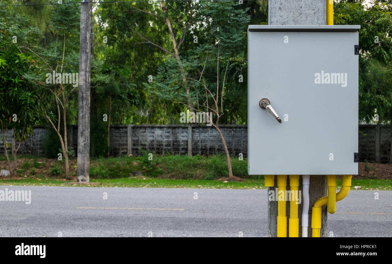 Une armoire électrique et le câblage de liaison avec du jaune et blanc tube transmetteur pendaison de béton poteau. Banque D'Images