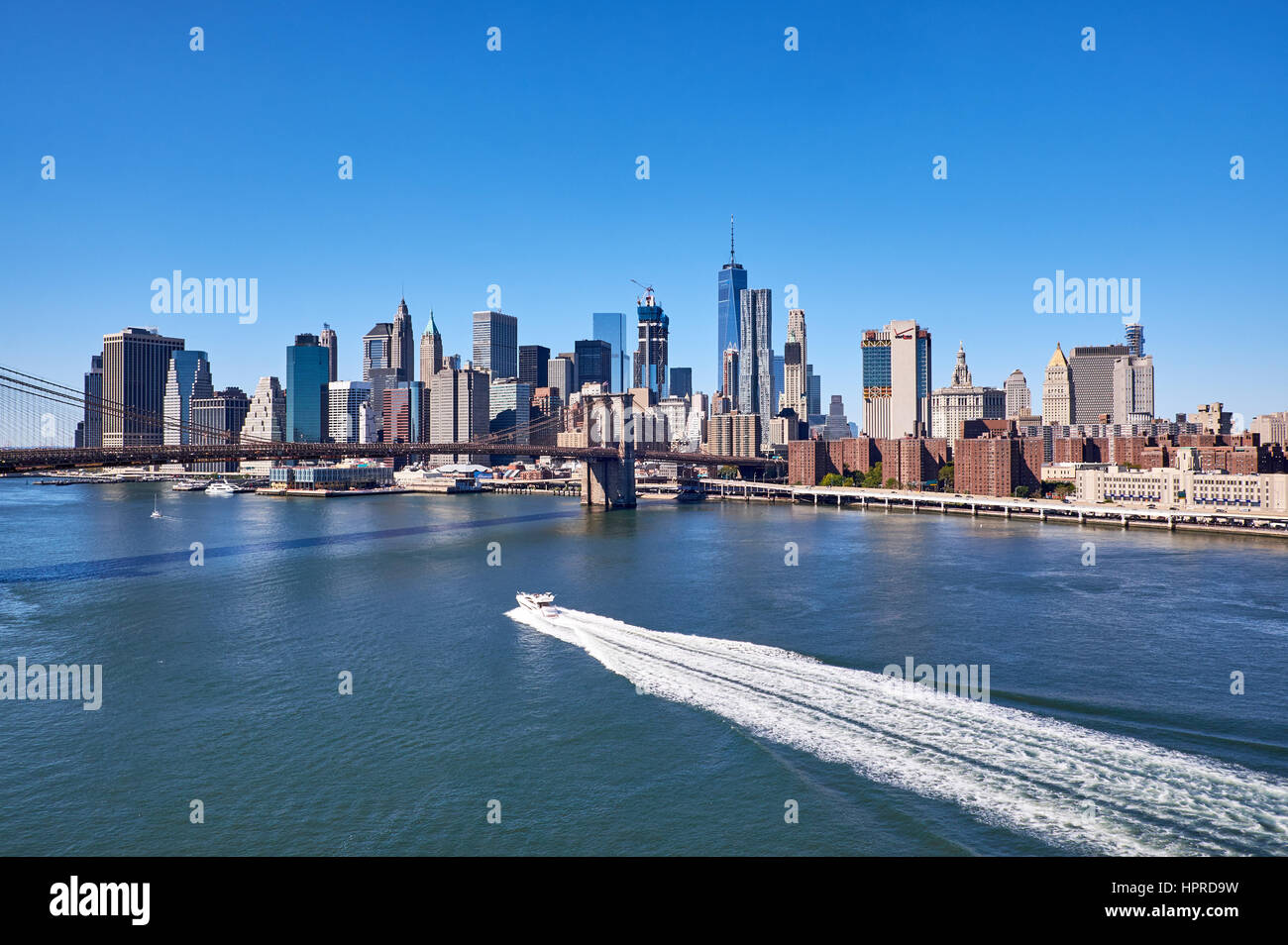 NEW YORK - 25 SEPTEMBRE : vue sur la rivière de l'est avec un bateau à moteur faisant un sentier blanc service en face de la skyline du quartier financier de Manhattan Banque D'Images