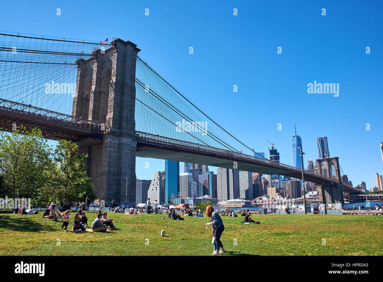 NEW YORK - 25 septembre 2016 : Les gens se détendre dans Fulton Ferry State Park sous le pont de Brooklyn, Manhattan skyline avec en arrière-plan Banque D'Images