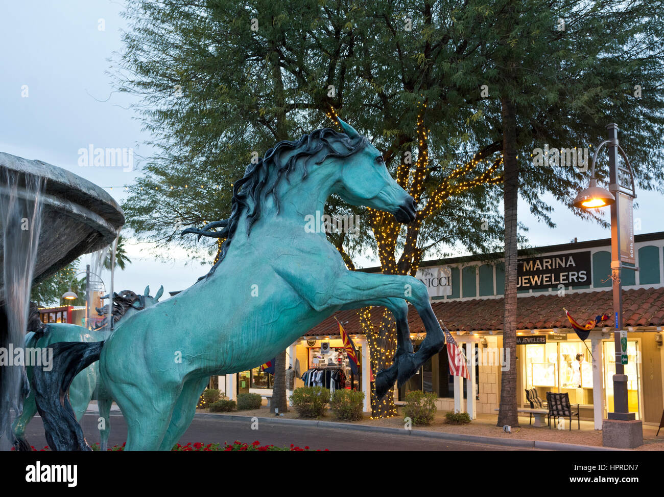 Fontaine avec des chevaux arabes de bronze sculptures et des boutiques sur la 5e Avenue, à Scottsdale, en Arizona, au crépuscule. Banque D'Images