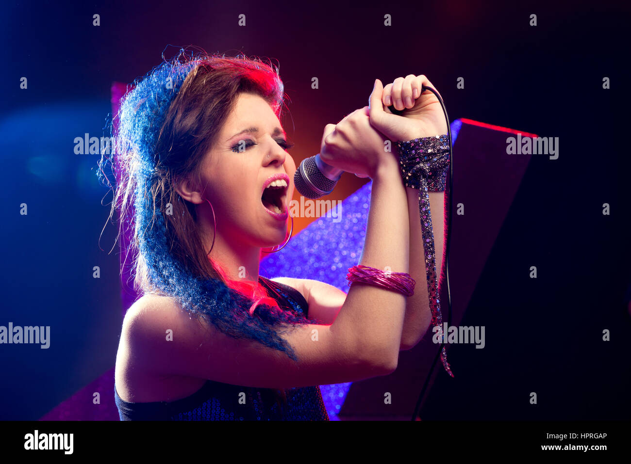 Les jeunes pop star girl singing sur scène close up. Banque D'Images