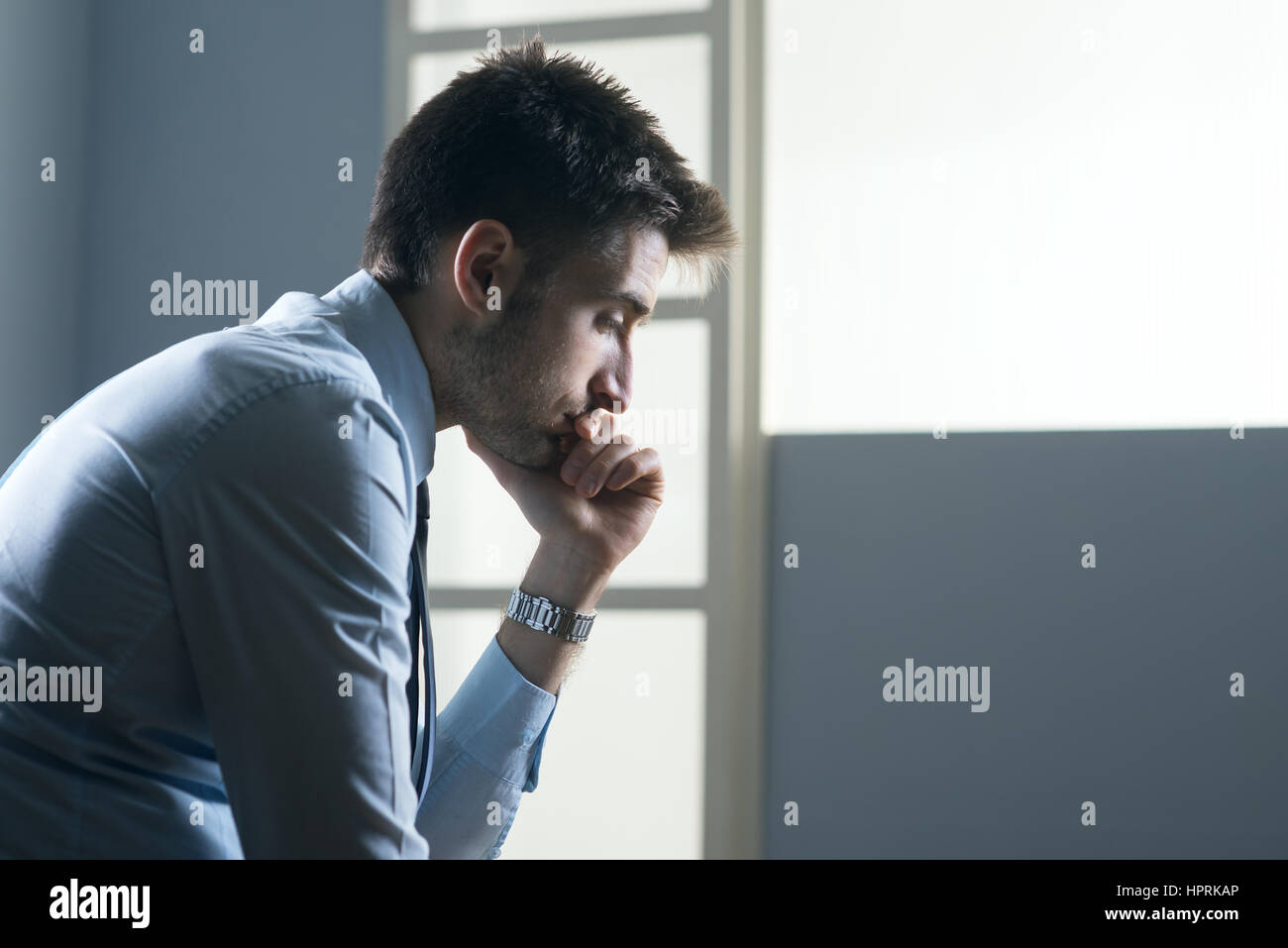 Fatigué pensive businessman with hand on chin. Banque D'Images Fatigué pensive businessman with hand on chin. Banque D'Images
