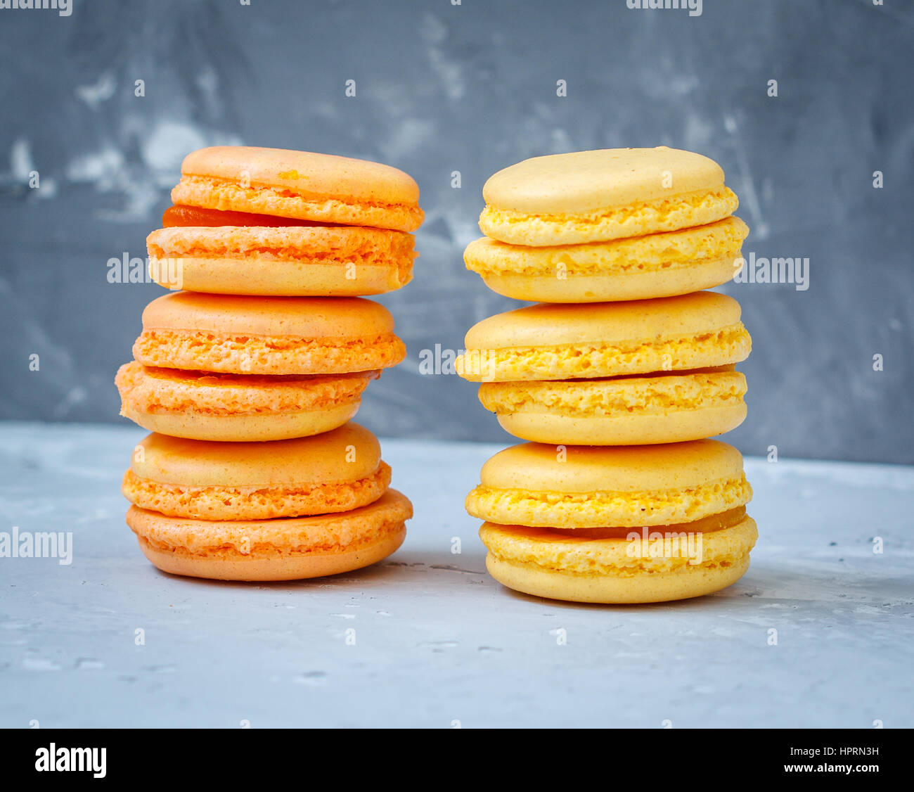 Des macarons citron et d'abricot sur un fond en béton. Banque D'Images