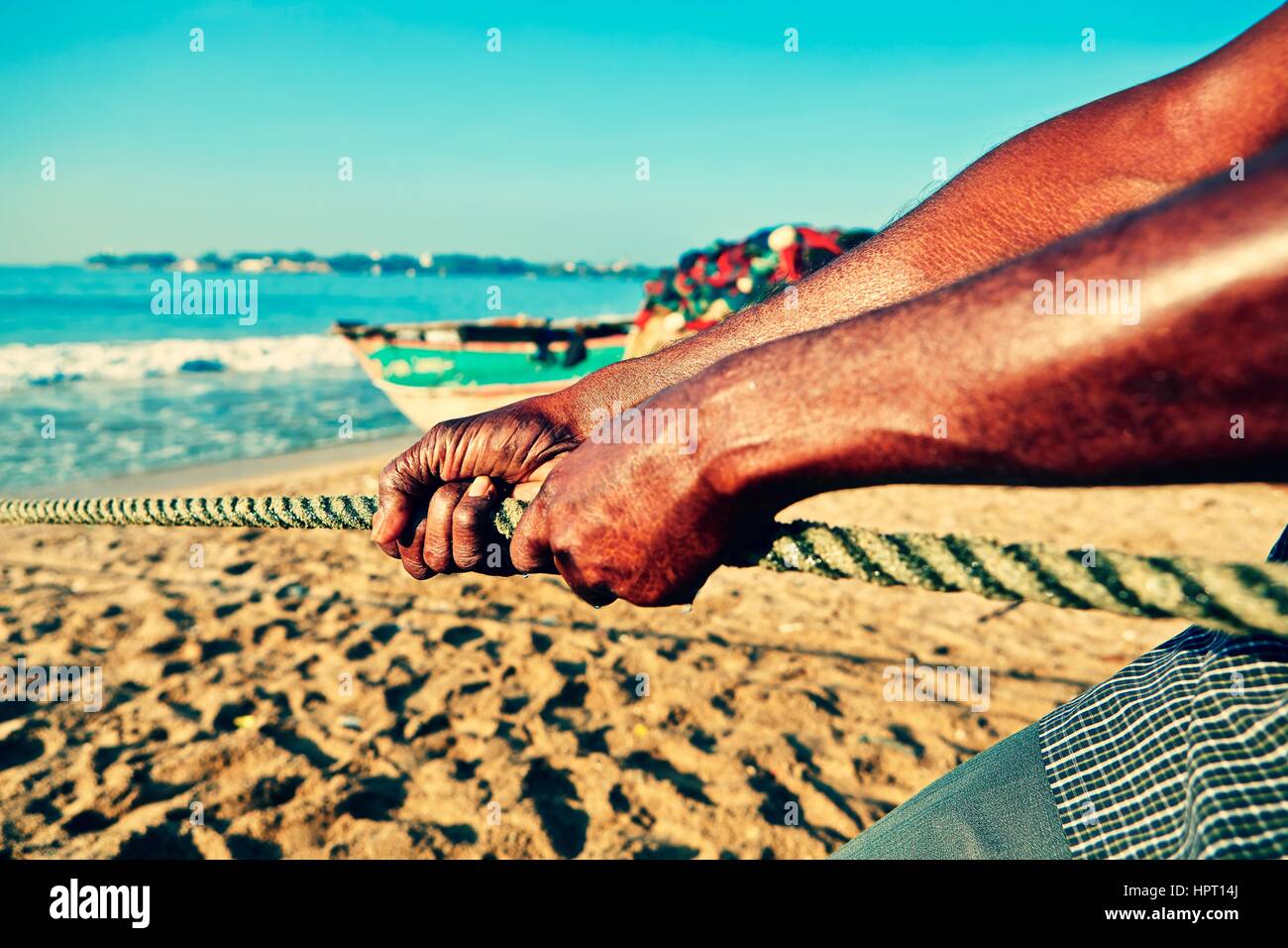 Est pêcheur tirant sur le net hors de la mer. Banque D'Images