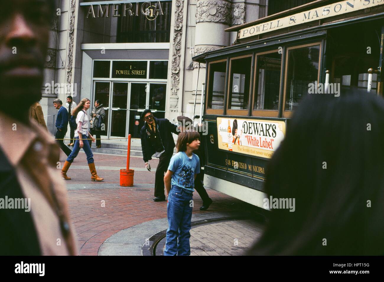 Un jeune garçon s'approche d'un Powell et Mason Street Line cable car à la platine de Powell Street, situé à proximité d'un Powell Street, dans le centre-ville de San Francisco, Californie, en tant que touristes à pied passé au premier plan, 1978. Banque D'Images