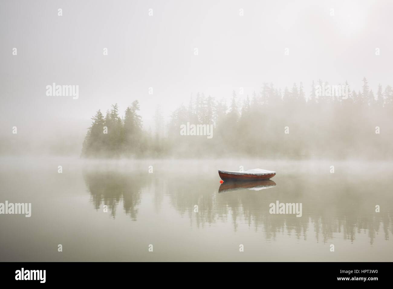 Bateau sur le lac au matin de brouillard. Banque D'Images