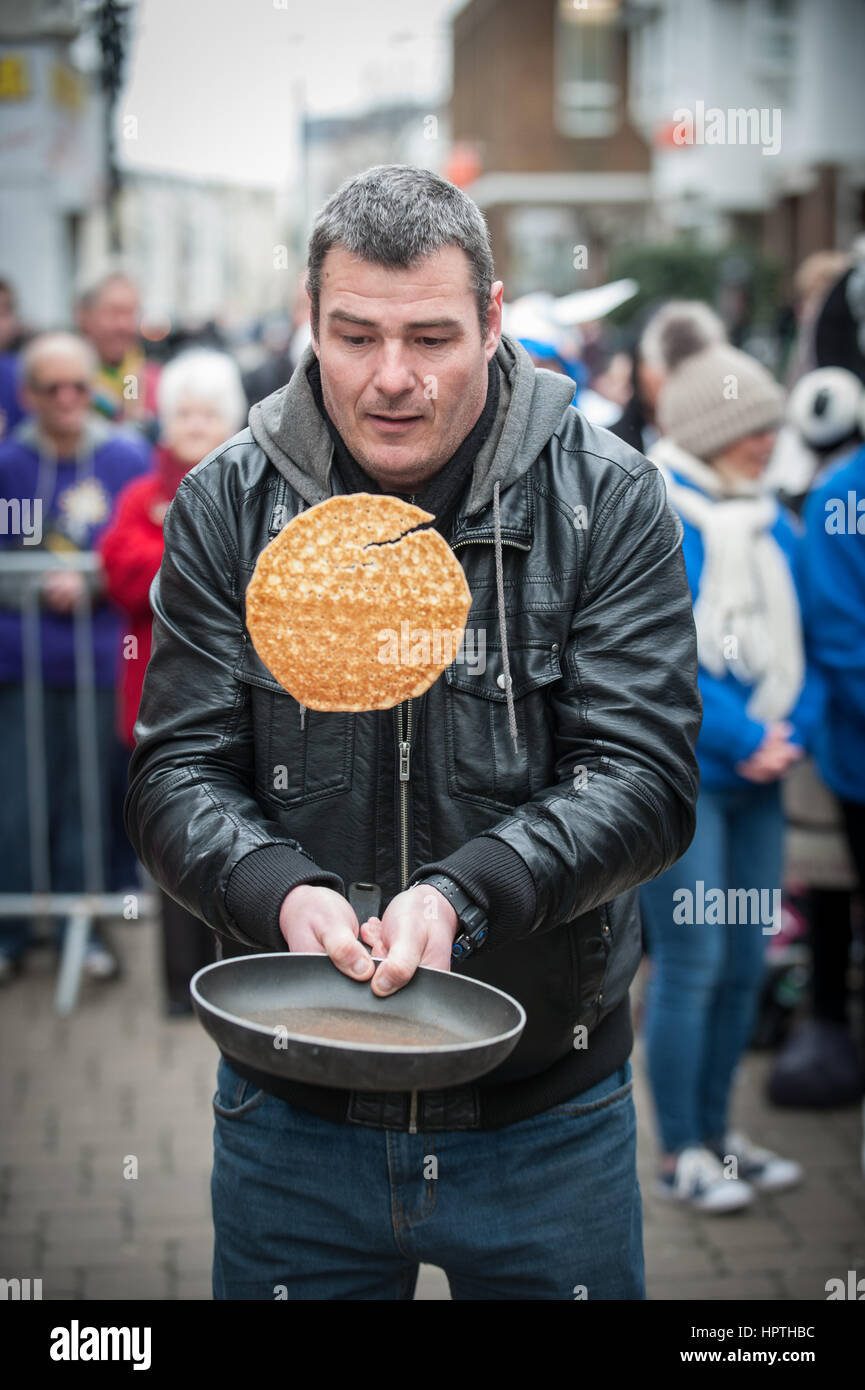 Un concurrent doit lancer une crêpe lors d'un concours de bienfaisance retournement de crêpe à Littlehampton, West Sussex, Angleterre, Royaume-Uni. Banque D'Images