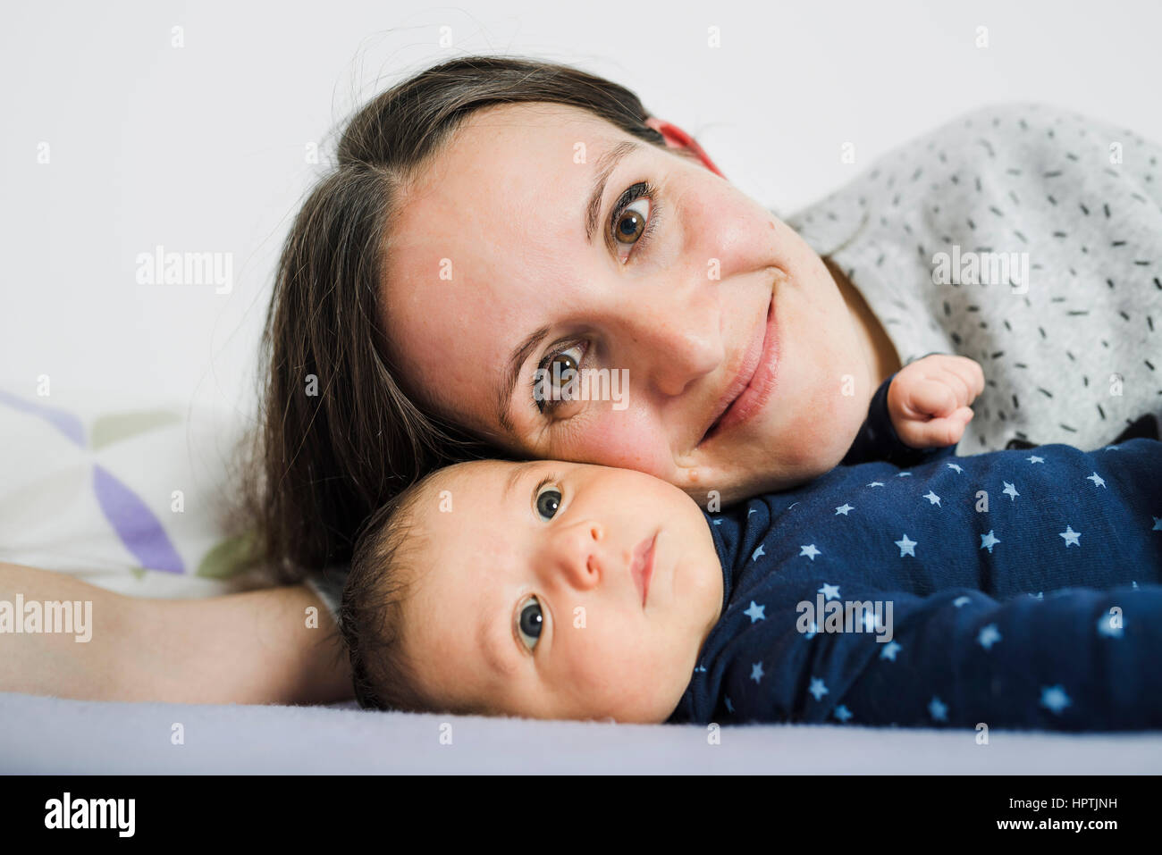 Heureuse mère au lit avec son nouveau-né fille Banque D'Images