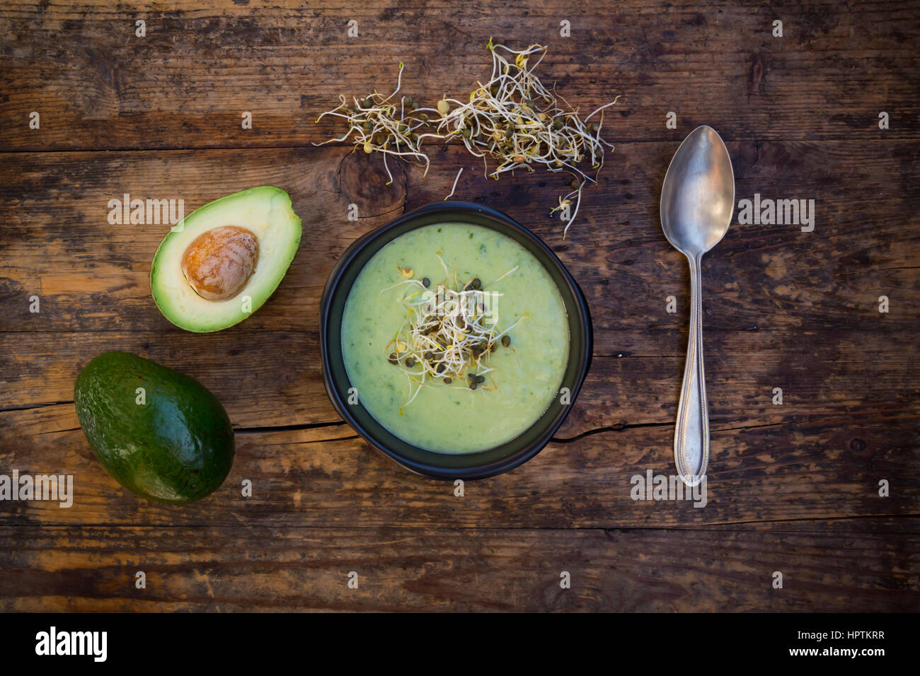 Bol de soupe de concombre avocat garni de pousses Banque D'Images