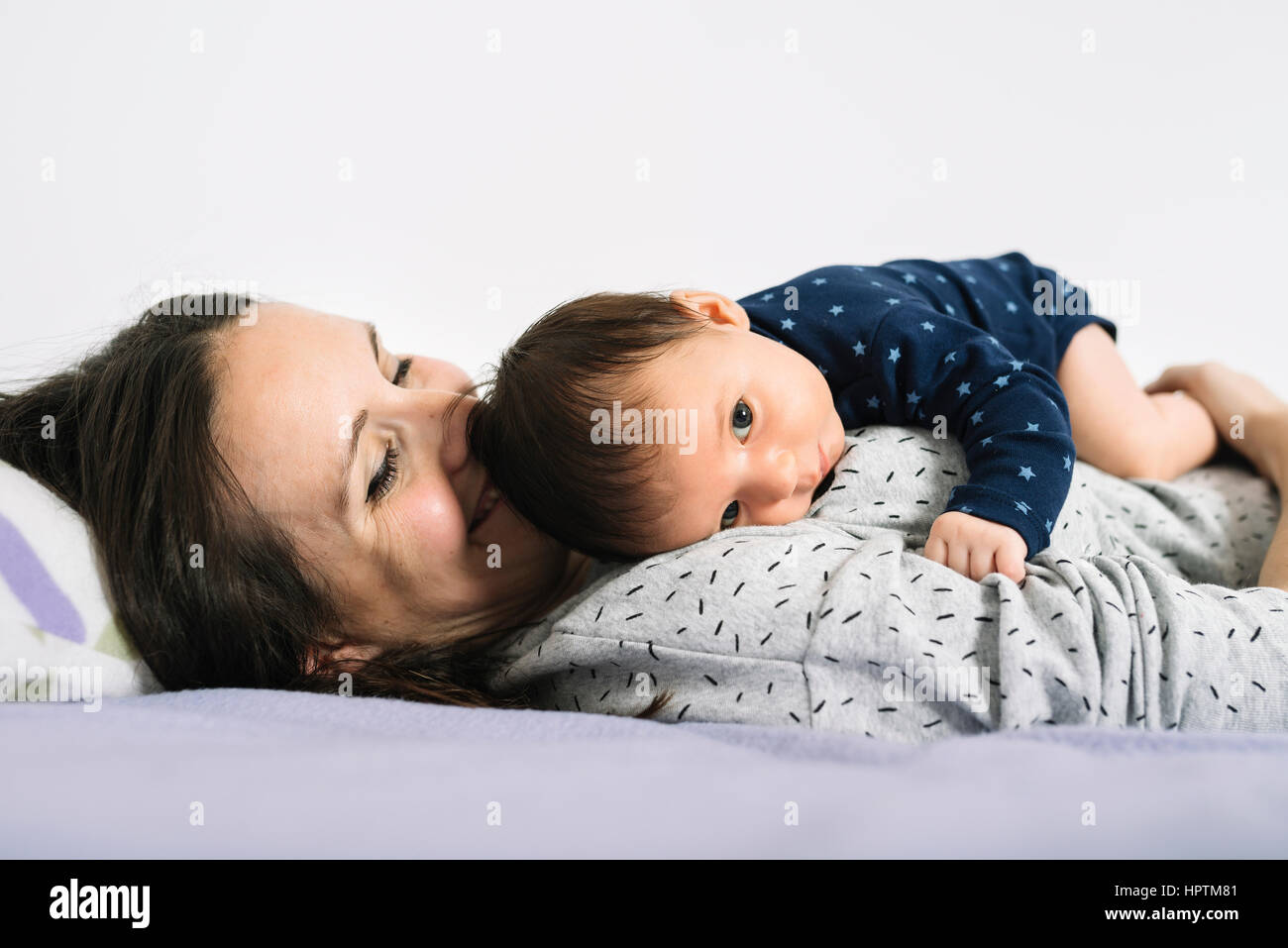 Mère au lit tenant son nouveau-né fille Banque D'Images