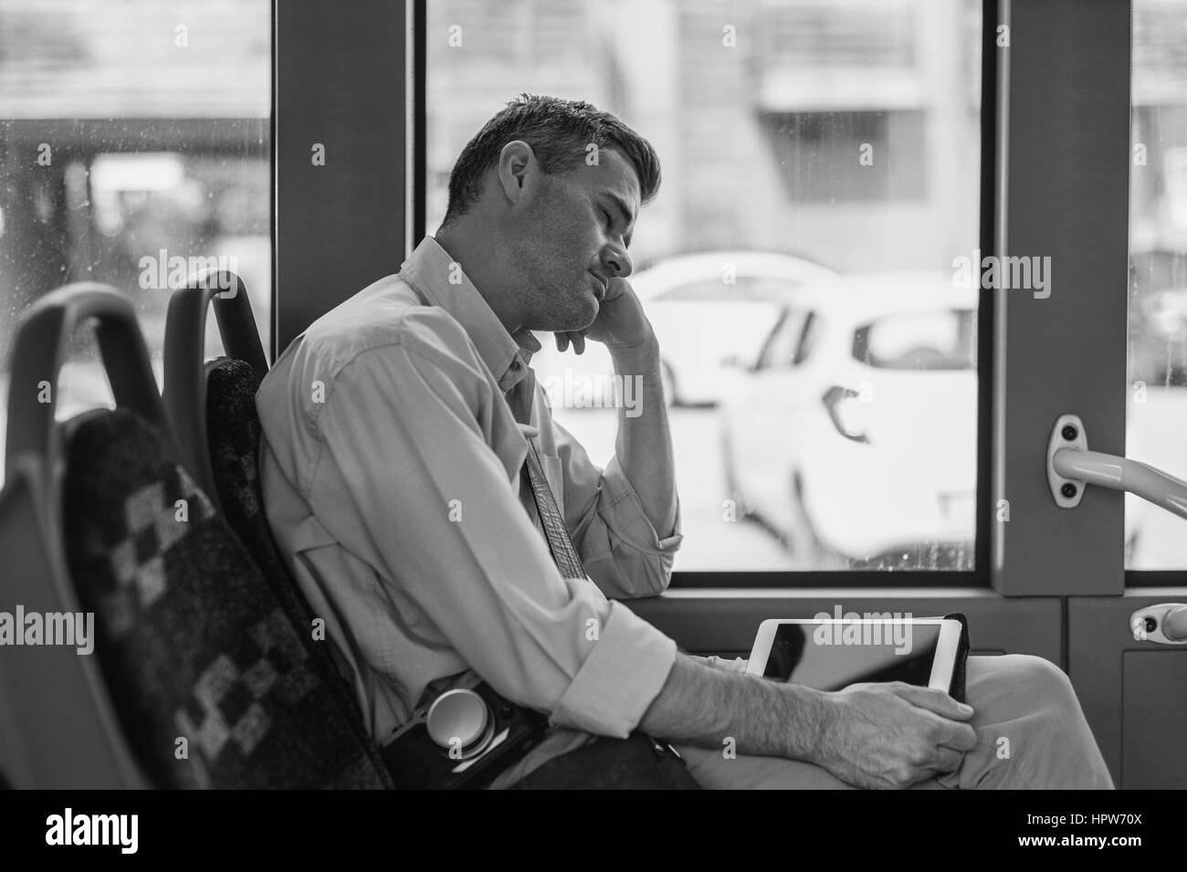 Homme fatigué de dormir dans le bus, elle est appuyée sur son bras Banque D'Images