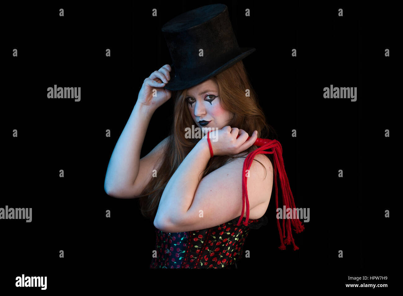 Jeune femme avec fouet rouge poli et le décollage des hat Banque D'Images
