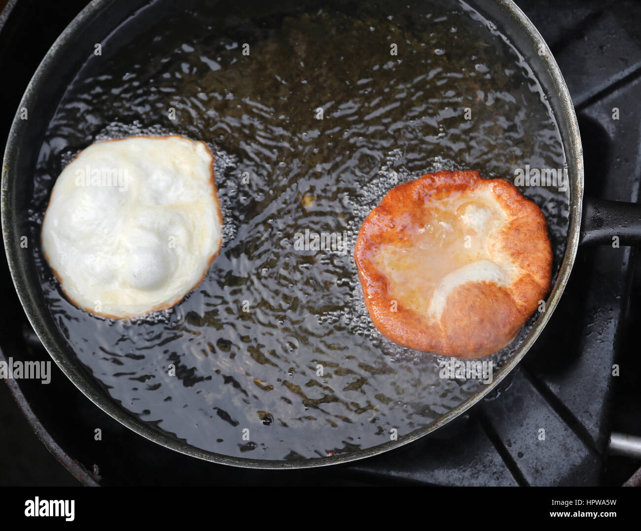 Deux crêpes frits dans une casserole d'huile chaude dans un stand de l'alimentation de rue en Europe Banque D'Images