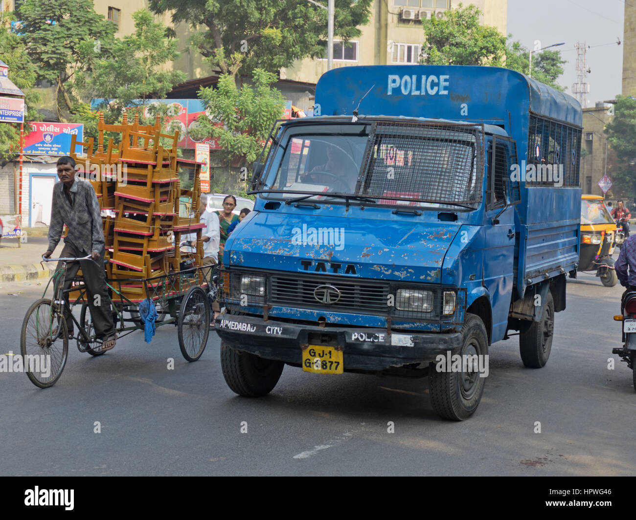 Camion de la police locale de faire son chemin à travers le trafic tôt le matin dans la vieille ville d'Ahmedabad, Inde Banque D'Images