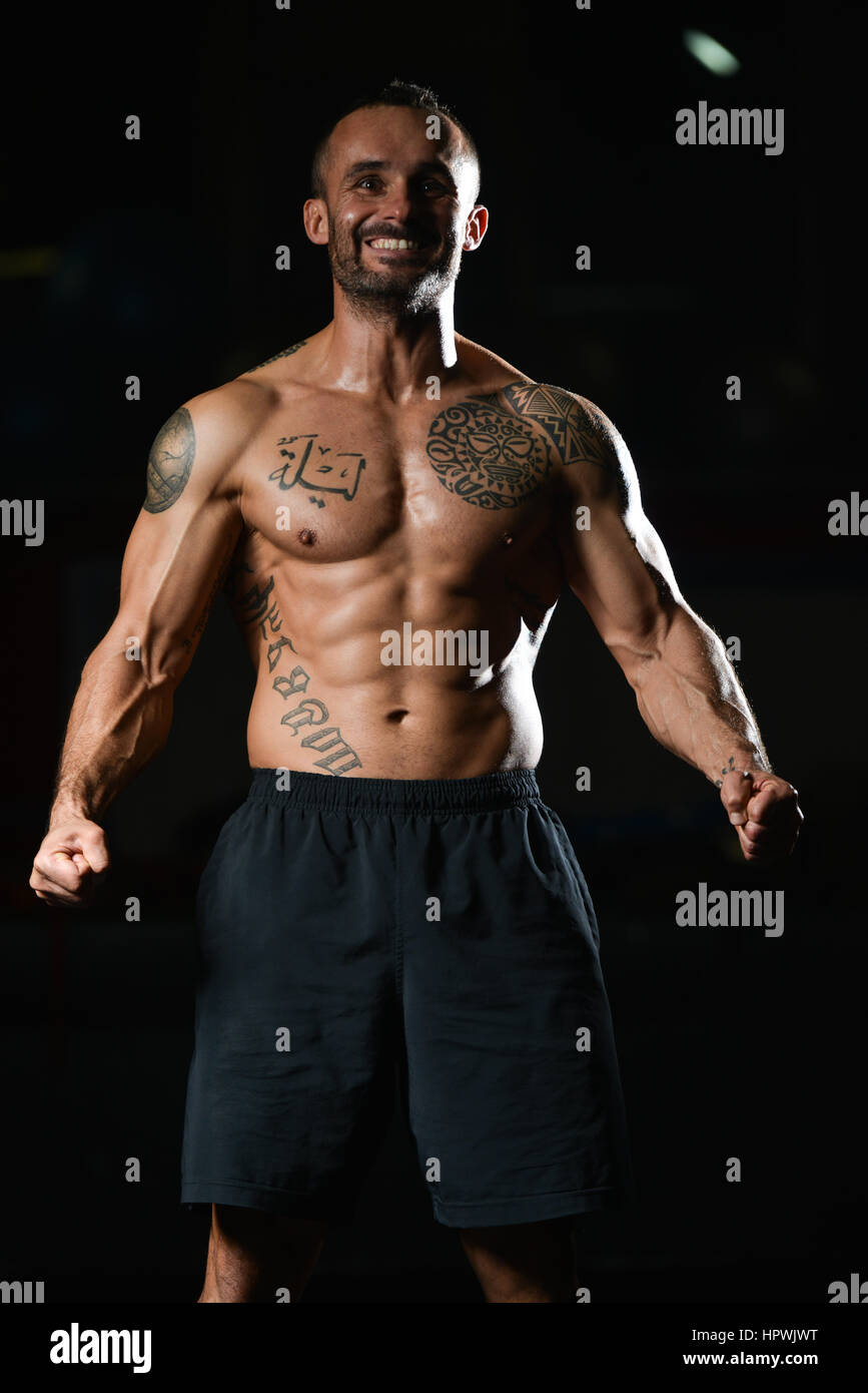 Jeune homme sain Tatouage Soyons forts dans la salle de sport et Flexing  Muscles musculaire - Fitness Model Posing Bodybuilder athlétiques exercices  après Photo Stock - Alamy