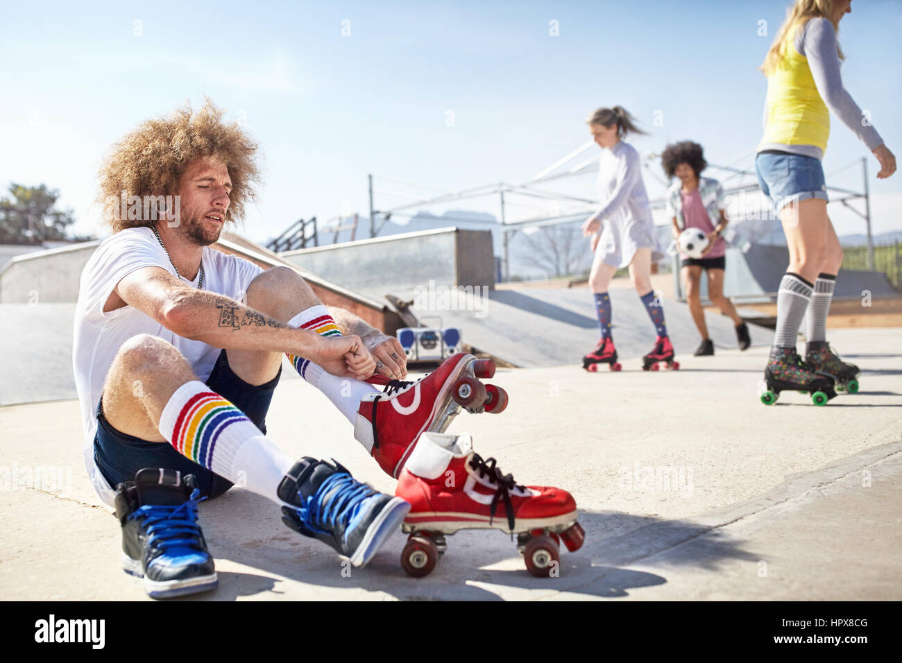Man putting sur patins à sunny au skate park Photo Stock - Alamy