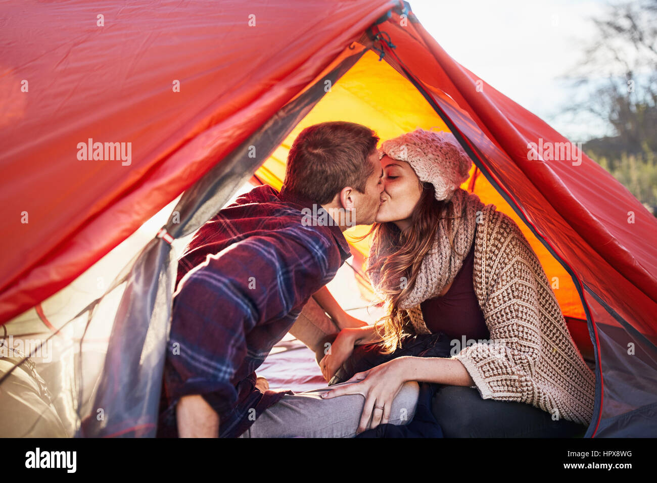 Jeune couple s'embrasser, à l'intérieur de tente de camping Banque D'Images