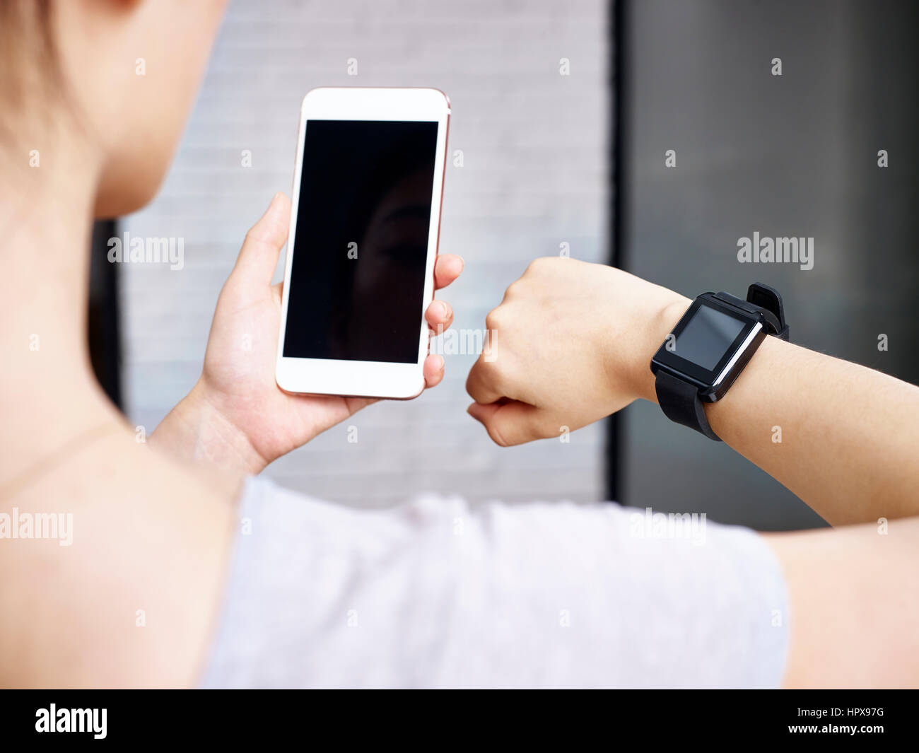 Libre coup de mains d'une femme utilisant smartphone et smartwatch ensemble. Banque D'Images