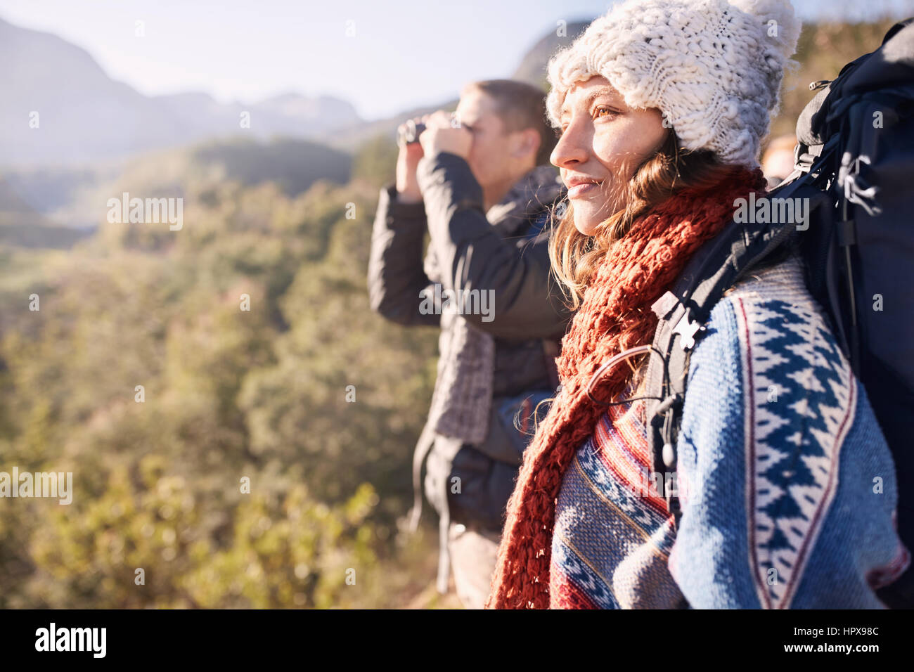 Jeune couple hiking, regardant le sunny view with binoculars Banque D'Images