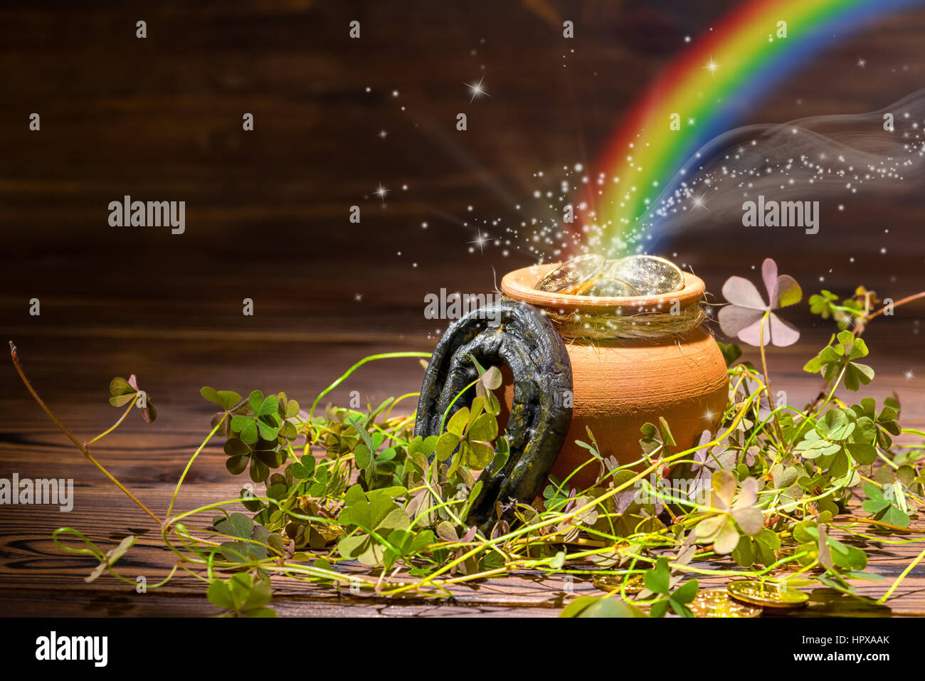 St Patricks day décoration avec arc-en-ciel de lumière magique plein pot des pièces d'or, fer à cheval et trèfles sur vintage background, Close up Banque D'Images