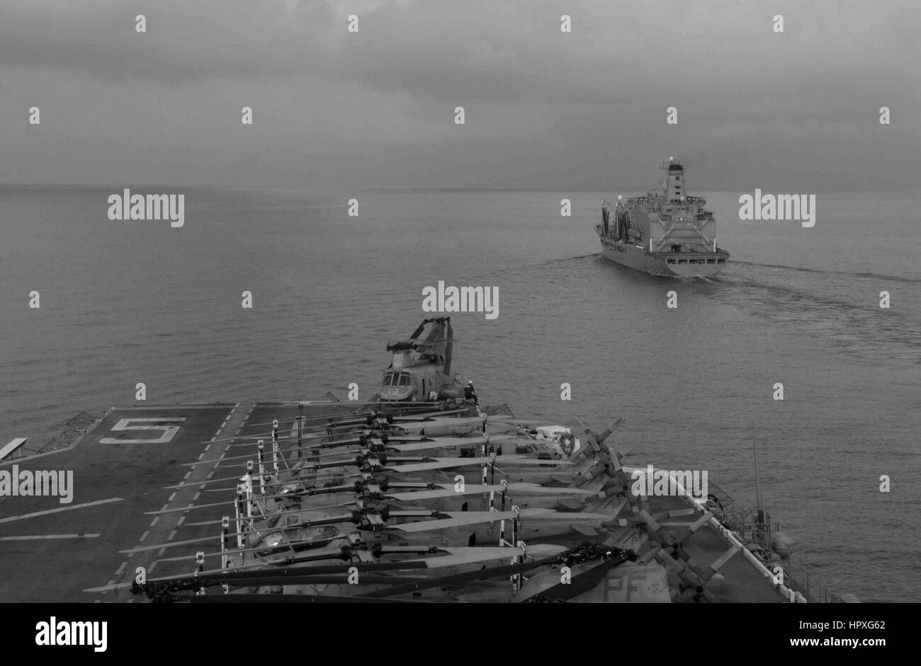 Navire d'assaut amphibie USS Peleliu (LHA 5) Transport maritime et militaire de la flotte commande reconstitution oiler USNS Pecos (T-AO 197) au cours d'un ravitaillement en mer, océan Indien, 2012. Image courtoisie de Stroop Derek Classe/US Navy. Banque D'Images