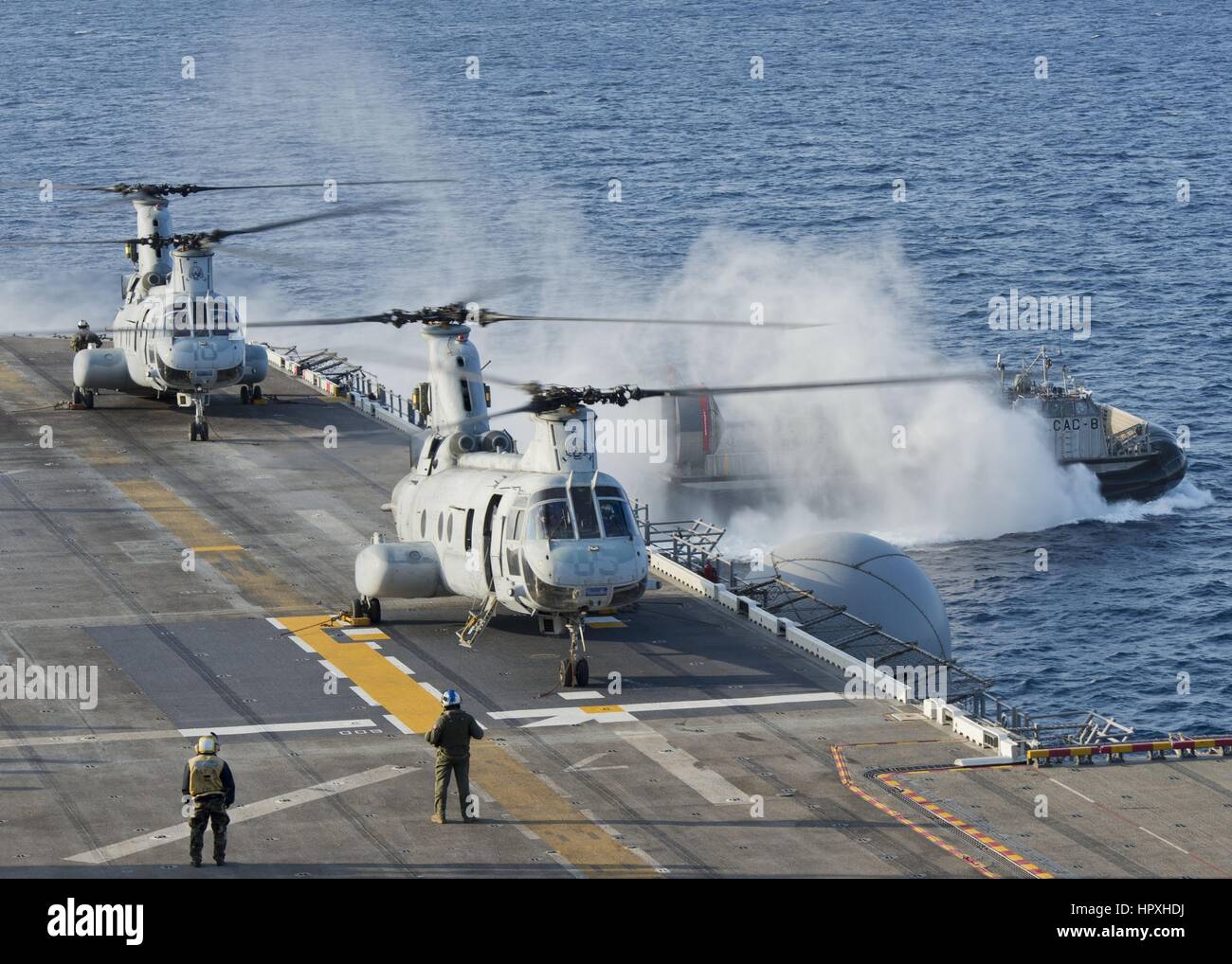 Landing Craft Air Cushion quitte le pont du coffre du navire d'assaut amphibie USS Bonhomme Richard, deux hélicoptères sur le pont d'envol, Mer de Chine orientale, 2013. Image courtoisie de l'US Navy. Banque D'Images